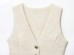 Détail du gilet en tweed crème avec col en V et boutons métalliques dorés en forme de cœur
