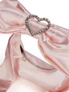 Dettaglio borsa in raso rosa con design a fiocco e fibbia a cuore in strass
