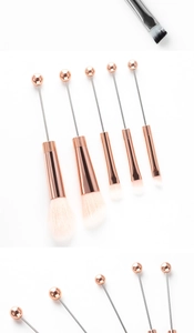 Close-up of rose gold ferrules and soft bristles on DIY beadable makeup brushes