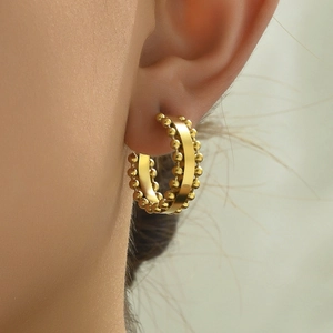 Detailed close-up of golden hoop earrings featuring micro-bead edges for women