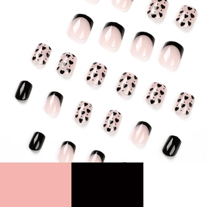 French tip press-on nails set with black heart designs and nude pink glossy finish