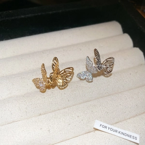 Detail of butterfly ear clips with hollow gold and silver plating and sparkling zircons
