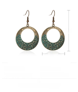 Détail montrant le poids et la taille des boucles d'oreilles ethniques en bronze ajouré