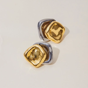 Macro view of bicolor geometric stacked square earrings with textured gold and silver metal