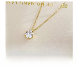 Close-up of sparkling cubic zirconia pendant with six-prong setting on gold titanium chain