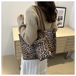 Detail view of large leopard print tote bag with matching coin purse on a model
