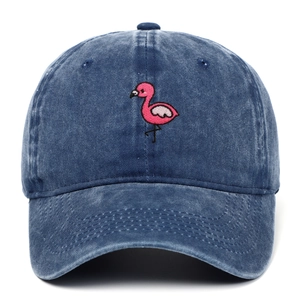 Close-up of pink flamingo embroidery and distressed texture on washed denim baseball cap