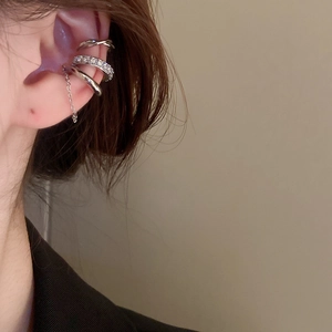Detail of silver ear cuff with sparkling zircon row and delicate chain tassel detail