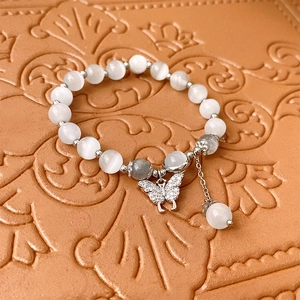 Détail macro du bracelet en perles œil-de-chat avec pendentif papillon serti de zircons
