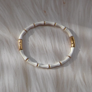 Bamboo-style bracelet in 18k gold plated stainless steel on white faux fur background