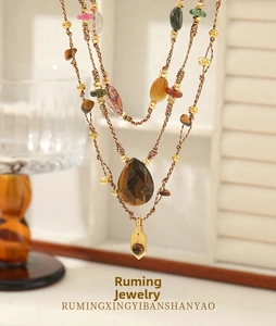 Detail of bohemian layered necklace with tiger eye stone pendant and colorful beads