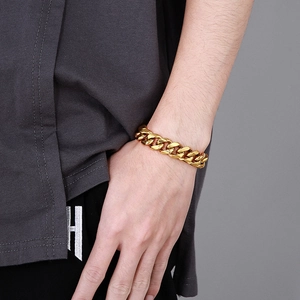 Detailed close-up of a gold Cuban link bracelet on a male wrist showing the bold CNC metal craft