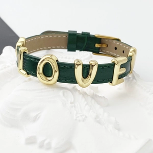 Detail of a dark green leather strap bracelet with gold metal LOVE letters on stone base
