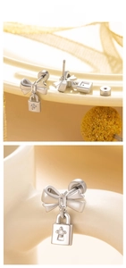 Macro detail of bow-knot screw back earrings with crystal padlock pendant in silver