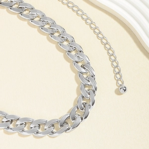 Macro shot of silver Cuban link chain with lobster clasp and round ball charm detail