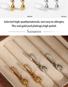 Detail of gold and silver teardrop earrings with pavé crystal hoops and PVD plating