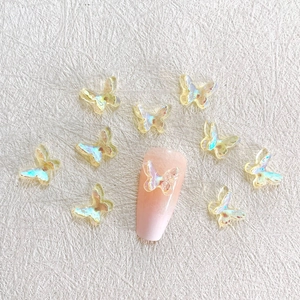 Detailed view of aurora iridescent resin butterfly charms applied on a pink nail tip