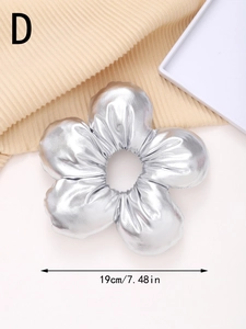 Detail shot of a metallic silver flower hair scrunchie showing a 19cm diameter size