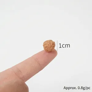 Miniature brown meatball food model 1cm diameter and 0.8g weight on fingertip
