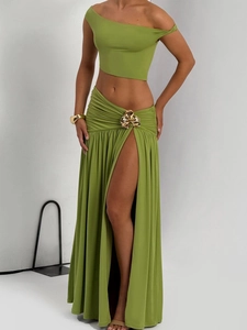 Detail of green two-piece set featuring gold petal buckle and thigh-high side slit
