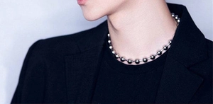 Close-up of a silver stainless steel bead chain necklace worn by a fashion model