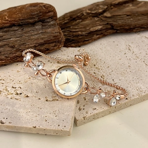 Detail of rose gold bracelet watch with crystal butterfly accents and adjustable closure