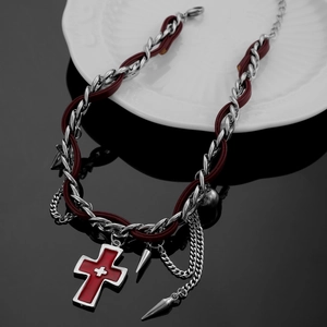 Detail of red enamel cross pendant on woven punk chain and burgundy leather cord