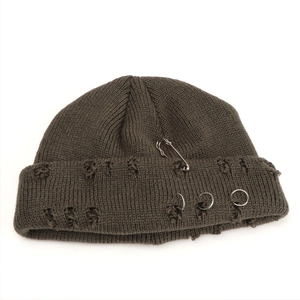 Close-up of distressed knit beanie with silver rings and safety pin in punk style