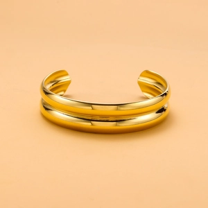Detail shot of the double-layer gold stainless steel open bangle with a polished finish