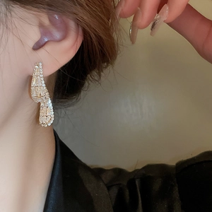 Close-up of model wearing gold square zircon earrings with twisted hollow design