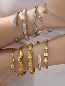 Détail de joncs superposés en or et argent avec zircons aux motifs bambou et vagues