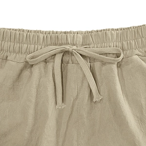 Detail of linen shorts featuring elastic waistband and adjustable braided drawstring
