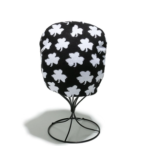 Gros plan du bonnet en maille avec des motifs de trèfle blanc sur tissu noir