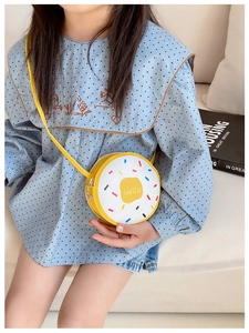 Detail showing a yellow donut-themed kids' crossbody bag with colorful stripes and Hello text