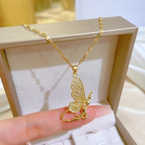 Detail view of a gold fairy pendant with butterfly wings inlaid with cubic zirconia