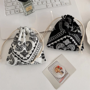 Detail view of cotton drawstring pouches with paisley pattern on an office desk setting
