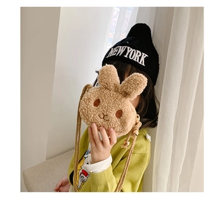 Detail of plush brown rabbit crossbody bag with rope strap and adjustable gold buckle