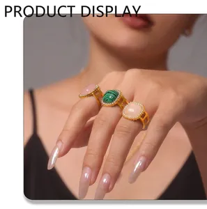 Detailed view of three stackable gold-plated rings with pink, green, and zircon gemstones
