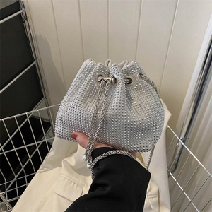 Silver rhinestone bucket bag with metal chain strap and pearl accents held by model