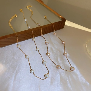 Detailed view of minimalist gold-plated necklaces with colorful freshwater pearls