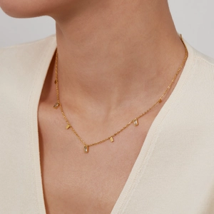 Minimalist gold stainless steel necklace with square zircon pendants worn by a model