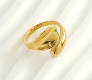 Close-up of polished 18k gold plated stainless steel bypass wrap ring on wave texture