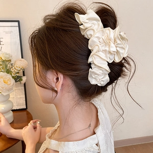 Elegant cream pleated fabric hair claw clip shown on model for a graceful hairstyle look