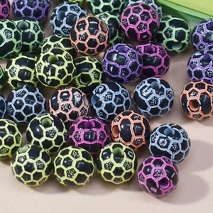 Macro shot of assorted colorful soccer-patterned acrylic beads for DIY sports jewelry