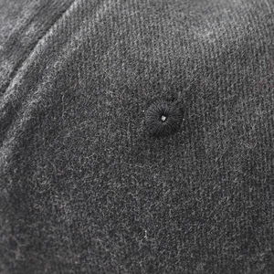 Macro shot of charcoal grey washed cotton fabric with detailed stitching and black eyelet