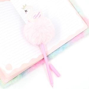 Pink swan plush pen with fluffy pom-pom and crown detail on a fuzzy notebook