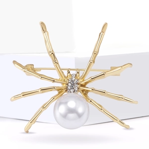Spider brooch with white pearl and sparkling crystals on gold metal, jewelry for clothing