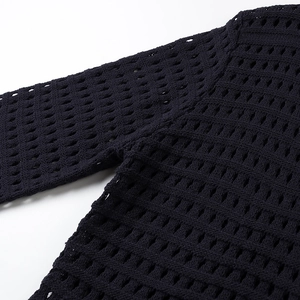 Close-up detail of the black mesh hollow knit fabric texture and shoulder seam on the top