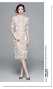 Detail of champagne satin cheongsam dress featuring elegant white floral embroidery