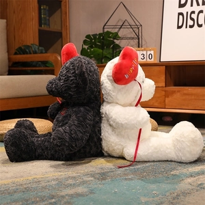 Detail of plush black and white teddy bears with red hearts embroidered with happily